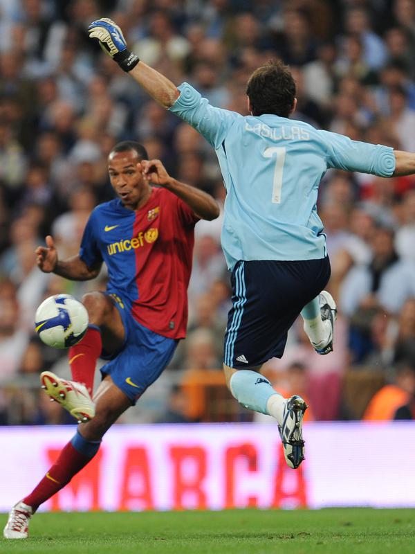 Kiper Real Madrid Iker Casillas berusaha menghalau bola tembakan penyerang Barcelona, Thierry Henry pada pertandingan La Liga Spanyol di stadion Santiago Bernabeu di Madrid pada 2 Mei 2009. (AFP/Javier Soriano)