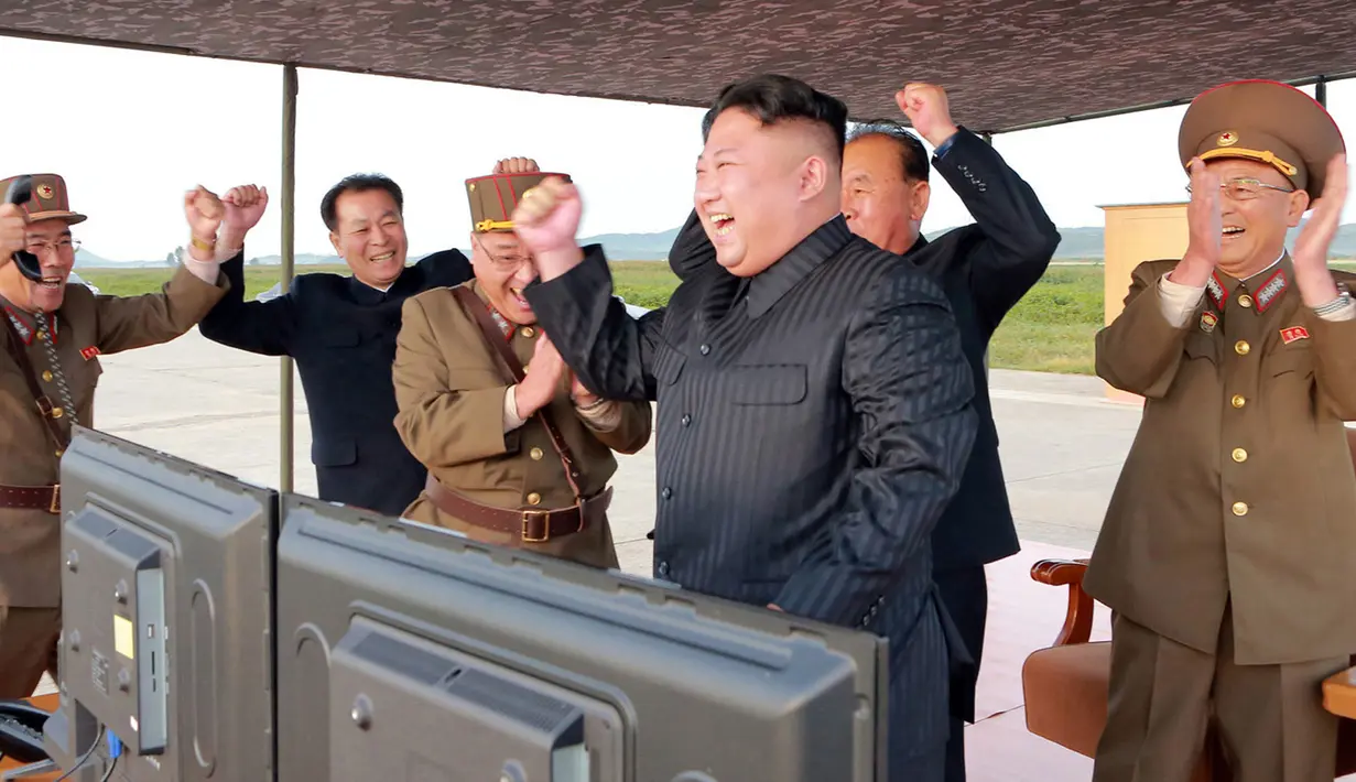 Pemimpin Korea Utara, Kim Jong-Un merayakan uji coba peluncuran rudal balistik Hwasong-12 di lokasi yang tak diketahui pada foto yang dirilis Sabtu (16/9). Rudal Hwasong-12 Korut pada Jumat ditembakkan menerobos langit Hokkaido Jepang (KCNA/KNS via AP)