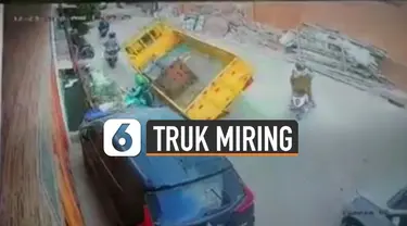 Terekam kamera CCTV sebuah truk miring saat lewati jalanan berlubang.
