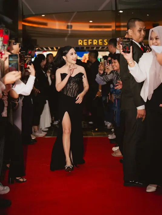 Dress hitam Prilly kali ini tanpa tali dengan atasan bustier yang dipenuhi payet dan manik-manik berkilauan, dipadu rok panjang menjuntai hingga ke lantai, dengan detail high slit. [Foto: Instagram/prillylatuconsina96]