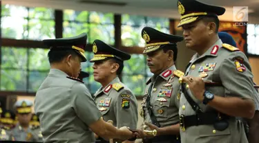 Kapolri Jenderal Tito Karnavian menyerahkan tongkat komando kepada Irjen Idham Aziz dalam acara sertijab di Rupatama Mabes Polri, Rabu (26/7). Idham Aziz resmi menjabat Kapolda Metro Jaya menggantikan Irjen Mochamad Iriawan (Liputan6.com/Faizal Fanani)