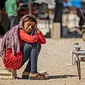 Seorang gadis Suriah yang terlantar menunggu pelanggan membawa buncis untuk digiling selama bulan suci Ramadan di kamp Washukanni untuk para pengungsi internal di provinsi Hasakeh di timur laut Suriah, (10/5/2020). (AFP/Delil Souleiman)