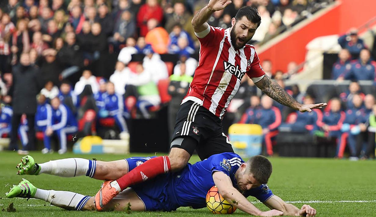 7. Bek Chelsea, Gary Cahill, terjatuh berebut bola dengan pemain Southampton, Charlie Austin pada laga Liga Premier Inggris di Stadion St Mary, Sabtu (27/2/2016). Southampton takluk 1-2 dari Chelsea. (Reuters/Dylan Martinez)