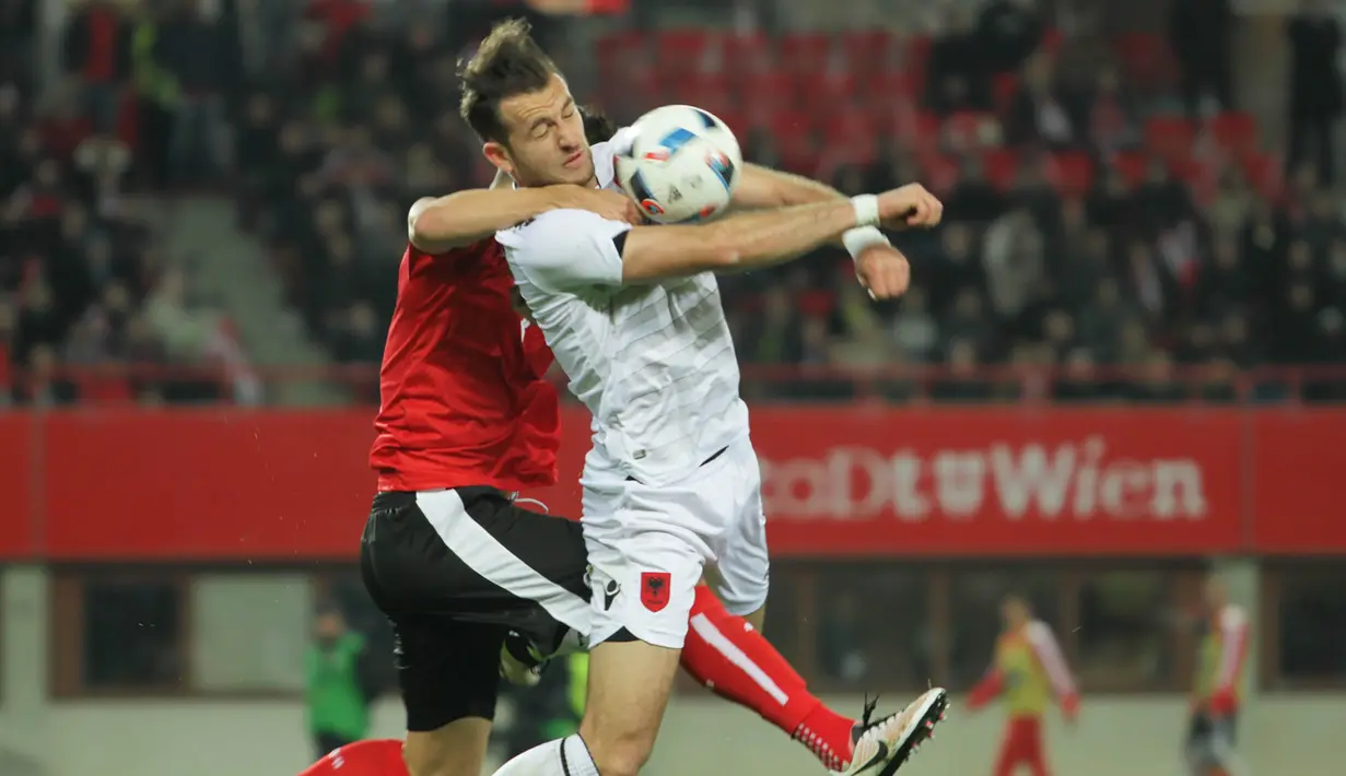 Bek Austria, Aleksander Dragovic (kiri) merangkul leher penyerang Albania, Sokol Cikalleshi, yang hendak menerima umpan lambung pada laga uji coba di Stadion Ernst Happel, Wina, Minggu (27/3/2016) dini hari WIB. (Bola.com/Reza Khomaini)