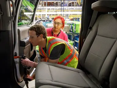 Founder sekaligus CEO Facebook, Mark Zuckerberg memasang sekrup pada mobil Ford saat kunjungan ke pabrik mobil pikap legendaris Ford F-150 di Dearborn, Michigan, AS. (Facebook/Mark Zuckerberg)