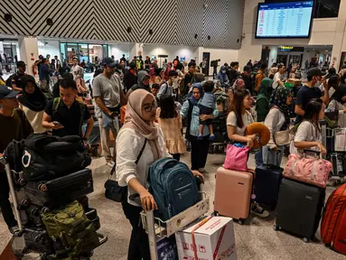 Calon penumpang melakukan lapor masuk di Bandara Internasional Juanda Surabaya di Sidoarjo, Jawa Timur, Sabtu 6 April 2024. (JUNI KRISWANTO/AFP)