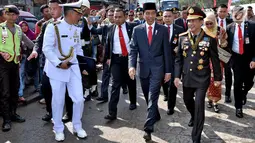 Presiden Joko Widodo didampingi Kapolri, Tito Karnavian beserta rombongan berjalan kaki menuju lokasi upacara HUT ke-72 TNI di Pelabuhan Indah Kiat, Banten (5/10). (Liputan6.com/Pool/Agus Suparto)