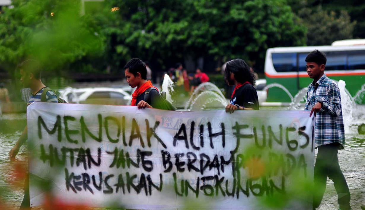 Sebuah spanduk berisi tuntutan mereka tampak dibentangkan dalam aksi unjuk rasa di Bundaran HI Jakarta, Jumat (12/12/2014). (Liputan6.com/Johan Tallo)