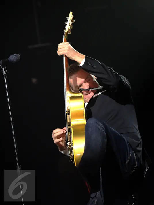 Penyanyi asal Kanada, Bryan Adams beraksi memainkan gitar saat menyanyikan lagu pertama pada konser "Get Up Tour" di Jakarta, Senin (16/1). Konser ini merupakan bagian tur untuk album ke-13 “Get Up”. (Liputan6.com/Helmi Fithriansyah)