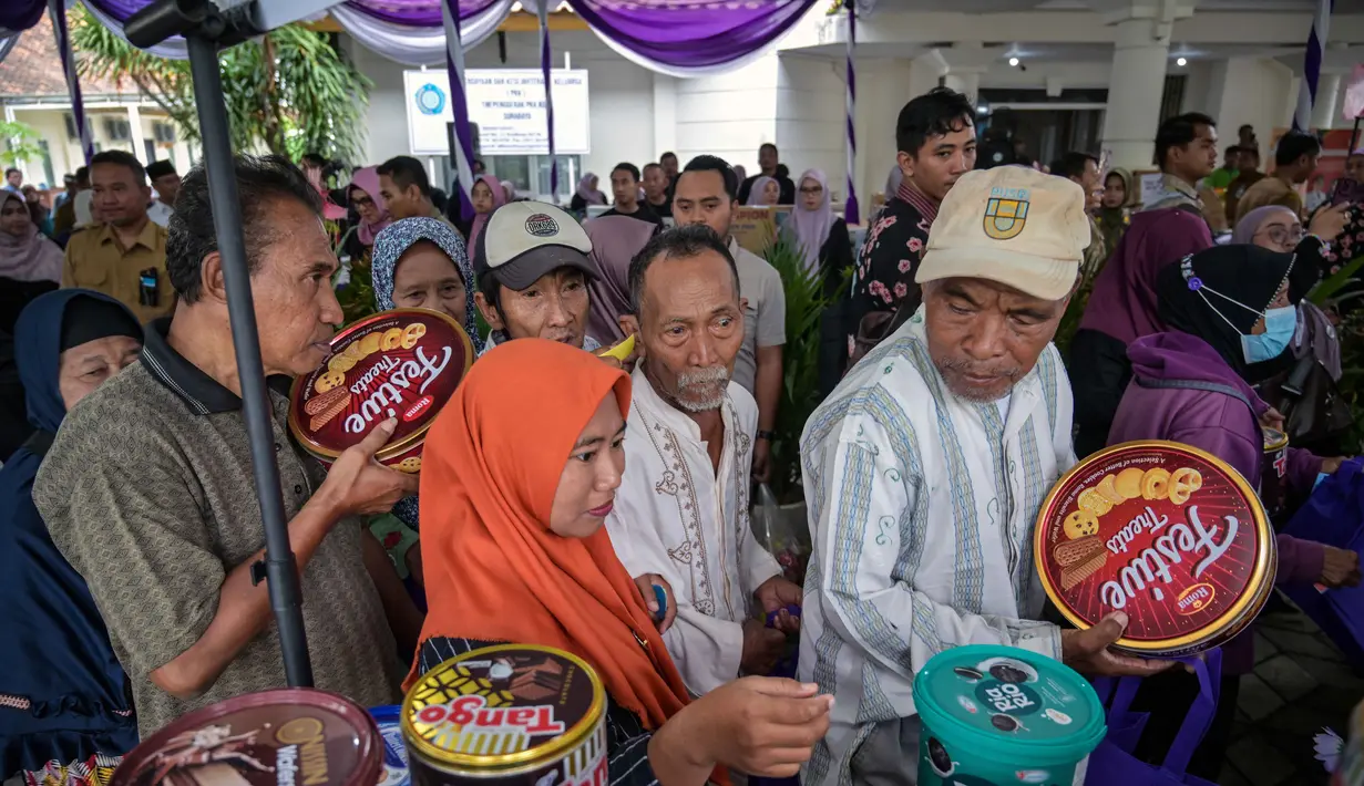 Aksi ini rutin dilaksanakan dalam momen khusus seperti bulan Ramadan. Tampak dalam foto, masyarakat menerima barang-barang gratis seperti pakaian, bahan makanan pokok, dan perlengkapan rumah tangga yang disediakan oleh Asosiasi Organisasi Wanita (GOW) dan pemerintah daerah selama kegiatan aksi sosial tahunan di bulan Ramadan, Surabaya pada Senin 2 Maret 2026. (JUNI KRISWANTO/AFP)