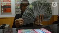 Petugas valas menghitung mata uang dolar AS di DolarAsia Valas di kawasan BSD, Tangerang Selatan, Banten, Selasa (16/4/2024). (merdeka.com/Arie Basuki)