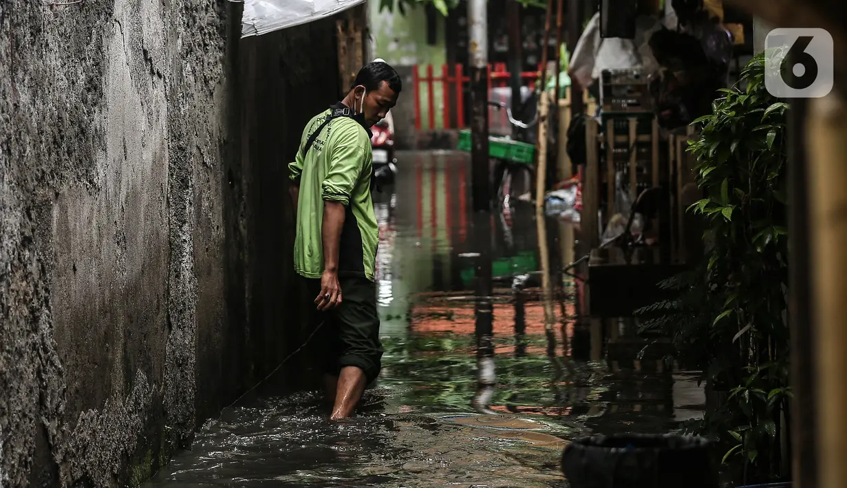 Warga menerobos banjir yang menggenangi lingkungan rumah tempat tinggal mereka di kawasan kecamatan Kebayoran Baru, Jakarta, Senin (25/01/2021). Hujan deras yang mengguyur Jakarta hari ini, Senin (25/1) menyebabkan terjadinya banjir di kawasan permukiman tersebut. (Liputan6.com/Johan Tallo)