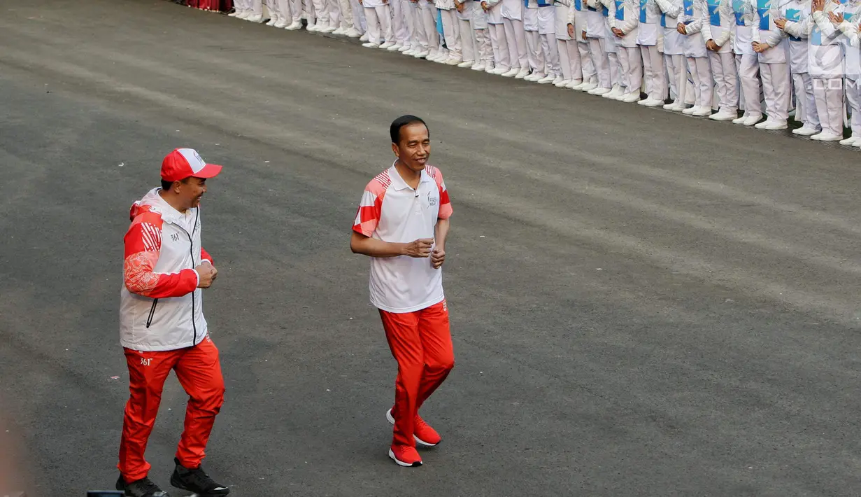 Presiden Joko Widodo didampingi Menpora Imam Nahrawi berlari pada acara api obor Asian Games 2018 sebelum upacara penurunan Bendera Merah Putih di Istana Negara Jakarta, Jumat (17/8). (Liputan6.com/Pool/Eko)