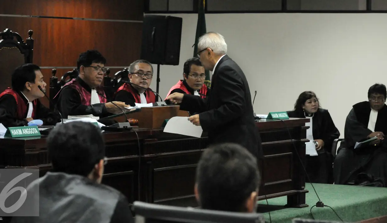 Terdakwa OC Kaligis memberikan dokumen kepada hakim saat sidang pemeriksaan terdakwa di Pengadilan Tipikor, Rabu (11/11). OC Kaligis didakwa dengan dugaan memberikan uang kepada 3 hakim dan panitera PTUN Medan. (Liputan6.com/Helmi Afandi)