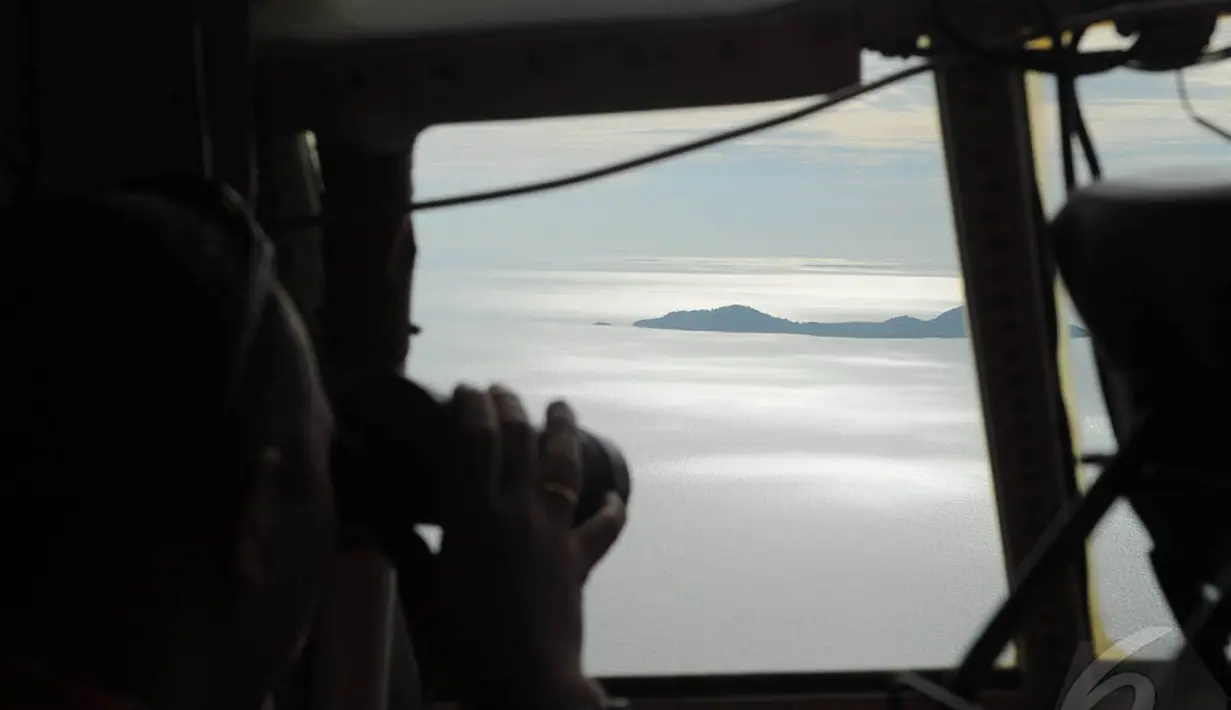 TNI AU tengah melakukan pemantauan diatas pesawat Hercules, dalam upaya pencarian pesawat AirAsia QZ8501 diatas selat Karimata, Belitung, Indonesia, Senin (29/12/2014). (Liputan6.com/Herman Zakharia)