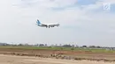 Sebuah pesawat melintas di atas proyek pembangunan runway dan taxiway 3 di Bandara Soekarno-Hatta, Tangerang, Kamis (21/6). Pembebasan lahan pembangunan runway di bandara Soetta sisi utara sudah mencapai 70 persen. (Liputan6.com/Angga Yuniar)