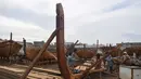Tukang kayu Pakistan menyelesaikan pembuatan kapal penangkap ikan di sebuah pelabuhan di Karachi (3/4). Pembuatan kapal buatan Pakistan menghasilkan ratusan kapal setiap tahun untuk memenuhi permintaan industri perikanan setempat. (AFP Photo/Asif Hassan)