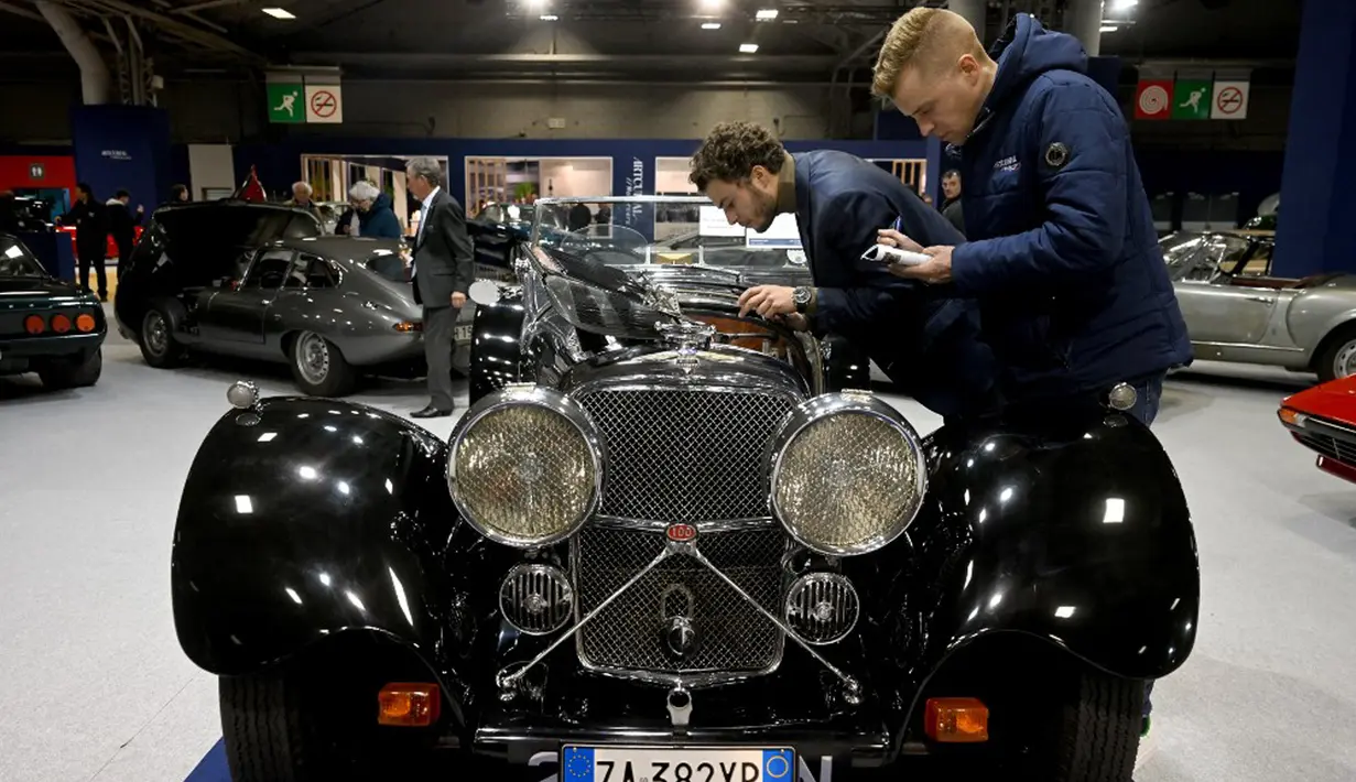 Pegawai rumah lelang memeriksa Jaguar SS100 Roadster 1936 saat pameran mobil klasik internasional Retromobile edisi ke-47 di Paris Expo Porte de Versailles, Paris, Prancis, 31 Januari 2023. Retromobile yang berlangsung pada tanggal 1 hingga 5 Februari 2023 menawarkan kesempatan kepada pengunjung untuk menemukan kembali model dan koleksi mobil klasik. (Emmanuel DUNAND/AFP)