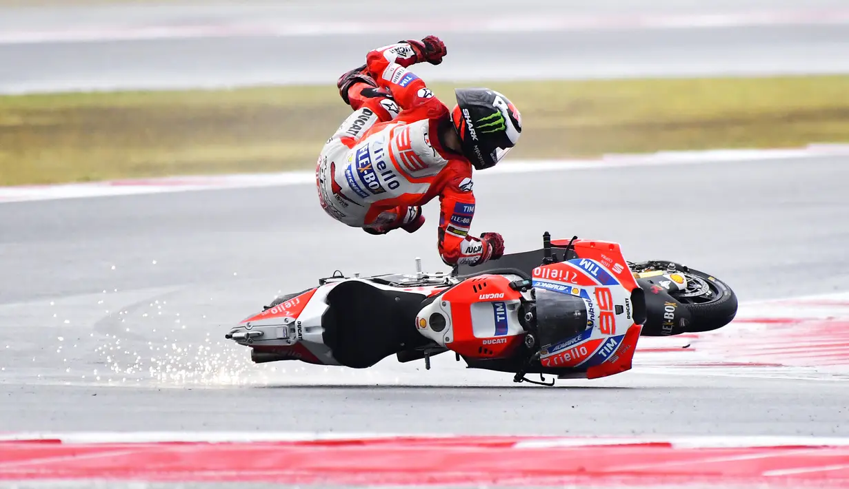 Pebalap Ducati, Jorge Lorenzo, terjatuh pada balapan MotoGP San Marino di Sirkuit Misano, Minggu (11/9/2017). Pebalap asal Spanyol itu hanya mampu melahap tujuh lap sebelum terjatuh di tikungan keenam. (AFP/Marco Bertorello)