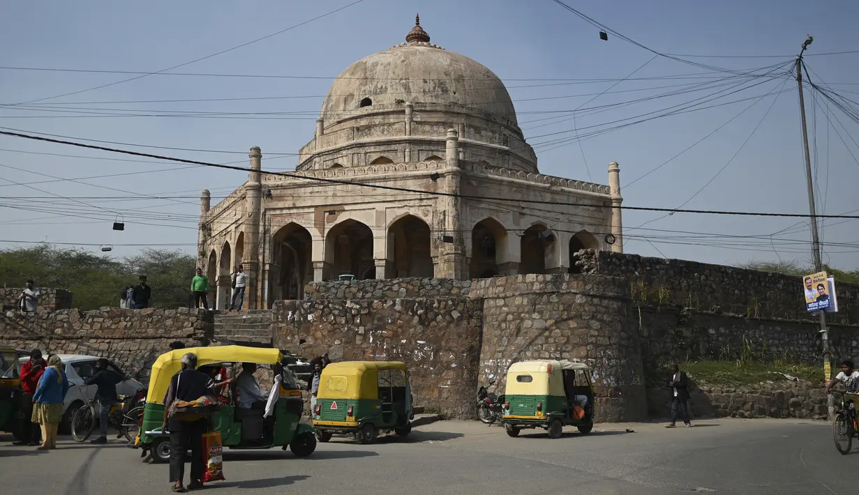 Pengemudi becak menunggu pelanggan di depan Makam Adham Khan abad ke-16, juga dikenal sebagai (Bhool Bhulaiya), di New Delhi (16/2/2022). Makam Adham Khan adalah makam Adham Khan abad ke-16, seorang jenderal Kaisar Mughal Akbar. (AFP/Sajjad Hussain)