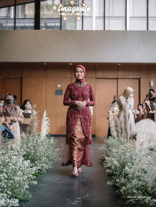 Kebaya merah marun tersebut kemudian dipadukan dengan bawahan songket yang senada, hijab segi empat merah marun, dan juga heels selop berpayet. (Instagram/ dindafirdausa.kebaya).