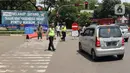 Polisi mengatur lalu lintas saat pengendalian mobilitas ganjil genap untuk pengunjung TMII di Jalan Pintu 1 TMII, Jakarta, Sabtu (18/9/2021). Pembatasan mobilitas pada TMII dan Taman Impian Jaya Ancol dilakukan pada hari Jumat-Minggu mulai pukul 12.00-18.00 WIB. (Liputan6.com/Herman Zakharia)