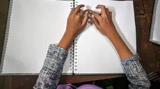 Seorang siswa tunanetra membaca Al-Quran dalam huruf Braille selama bulan suci Ramadan 1447 Hijriah di sebuah sekolah di Surabaya, Jawa Timur, pada 27 Februari 2026. (JUNI KRISWANTO/AFP)
