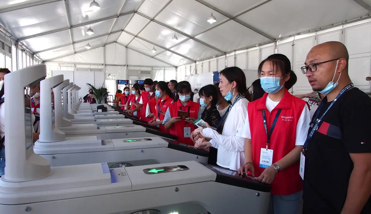 Para sukarelawan membantu pengunjung melewati pintu masuk di Pameran Buku Shanghai 2020 di Shanghai, China (12/8/2020). Pameran Buku Shanghai 2020 dimulai 12 dan 18 Agustus harus mendaftar dengan nama asli mereka, menunjukkan kode kesehatan, memakai masker, dan memeriksa suhu. (Xinhua/Ren Long)
