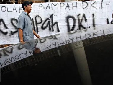 Warga melintas depan spanduk penolakan sampah DKI Jakarta di Jalan Raya Narogong, Bogor Timur, Jawa Barat, Rabu (4/11/2015). Ormas bersama warga menyatakan akan tetap menolak truk sampah yang melintas di kawasan tersebut. (Liputan6.com/Immanuel Antonius)