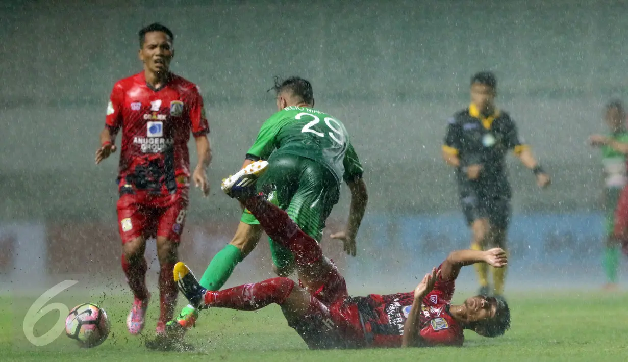 Pemain Persiba, Ardhi Yuniar (bawah) terjatuh saat menahan pergerakan penyerang PS TNI Elio Bruno Teixeira dilanjutan Liga 1 Indonesia di Stadion Pakansari, Kab Bogor, Jumat (5/5). Laga kedua tim berakhir imbang 1-1. (Liputan6.com/Helmi Fithriansyah)