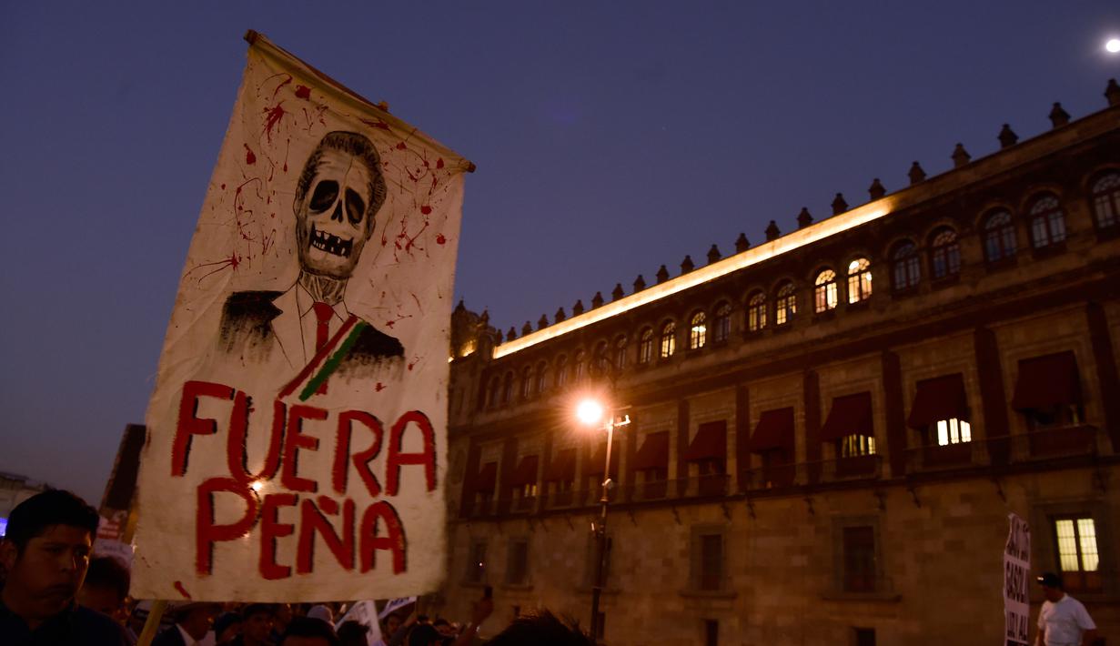 Pengunjuk rasa mengangkat poster tengkorak Presiden Enrique Pena Nieto saat demonstrasi menolak kenaikan harga BBM, Mexico City, Meksiko (9/1). Akibat kenaikan BBM, sebagian warga nekat melakukan aksi vandalisme hingga penjarahan. (AFP/Alfredo Estrella)