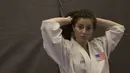 Karate Amerika Serikat merapihkan rambut sebelum tampil pada Kejuaraan Dunia Karate Junior, Cadet, dan U-21 2015. (Bola.com/Vitalias Yogi Trisna)