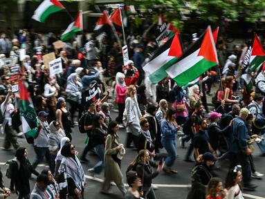 Para pengunjuk rasa memegang plakat dan mengibarkan bendera Palestina saat mereka mengambil bagian dalam “Pawai Nasional untuk Gaza”, di pusat kota London, pada 8 Juni 2024. (JUSTIN TALLIS/AFP)