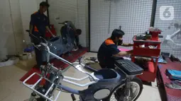 Mekanik saat memodifikasi motor di Jakarta, Selasa (29/3/2022). Modifikasi motor tersebut merupakan konversi  bahan bakar minyak ke motor listrik. (merdeka.com/Imam Buhori)