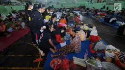 Petugas gabungan melakukan pendataan kepada pengungsi di Gor Swecapura, Klungkung, Bali, Sabtu (30/9). Pendataan tersebut dimaksudkan untuk mengetahui warga yang ikut evakuasi namun tidak dalam zona merah Gunungapi Agung. (Liputan6.com/Gempur M Surya)