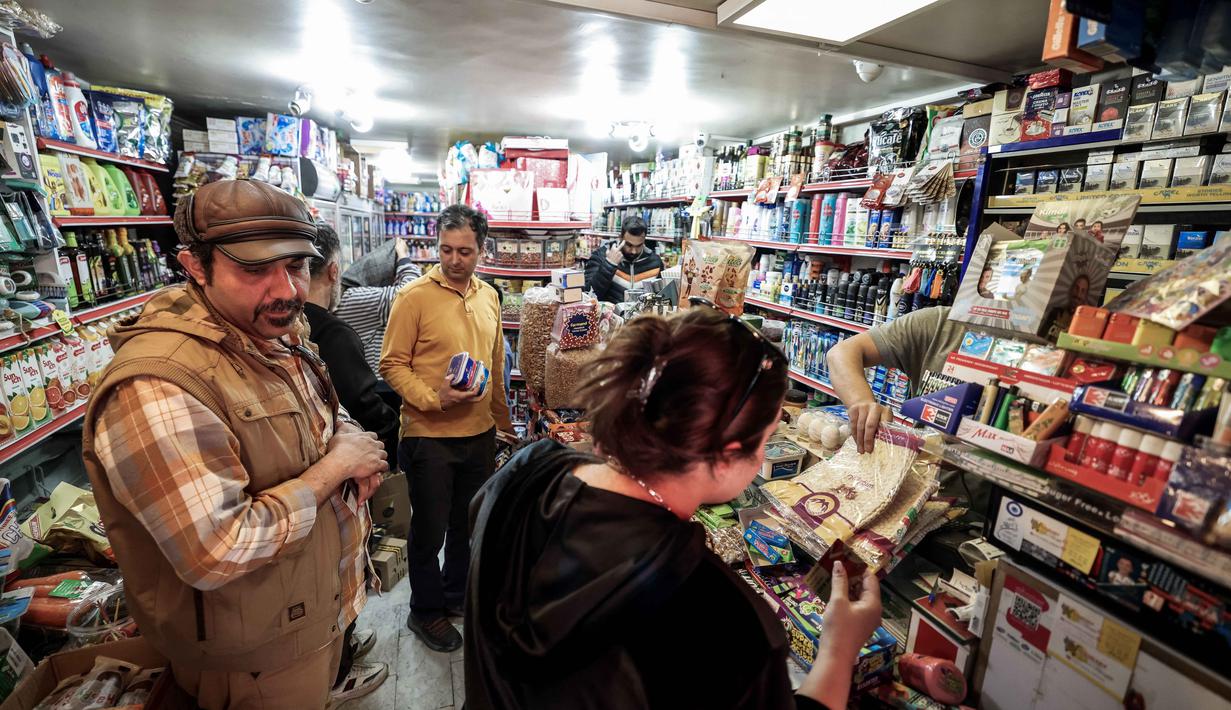 Warga Iran juga memadati pusat-pusat ritel untuk berbelanja bahan makanan. Tampak dalam foto, orang-orang berbelanja bahan makanan di sebuah toko di Teheran, Iran pada Sabtu 28 Februari 2026. (Atta KENARE/AFP)
