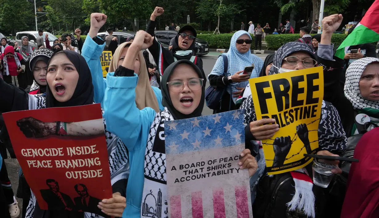 Dalam aksinya, massa membawa spanduk bertuliskan penolakan dan mendesak pemerintah Indonesia untuk menarik diri dari keanggotaan badan tersebut. Tampak dalam foto, aktivis Muslim memegang poster dan meneriakkan slogan-slogan selama unjuk rasa dukungan untuk warga Palestina di Gaza, di depan Kedutaan Besar Amerika Serikat, Jakarta, Jumat 13 Februari 2026. (AP Photo/Achmad Ibrahim)