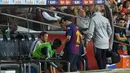 Megabintang Barcelona, Lionel Messi meninggalkan lapangan setelah cedera saat melawan Sevilla dalam lanjutan Liga Spanyol di Camp Nou, Minggu (21/10). Messi mengalami cedera patah tulang tangan akibat salah tumpuan ketika terjatuh. (LLUIS GENE / AFP)