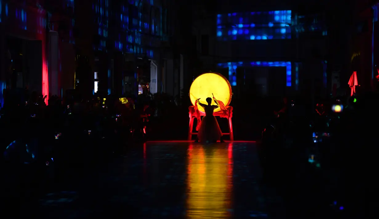 Seorang aktor menari sebelum dimulainya peragaan busana brokat Li, pakaian tradisional yang dibuat oleh kelompok etnis Li, di Haikou, Provinsi Hainan, China selatan, pada 19 November 2020. (Xinhua/Guo Cheng)