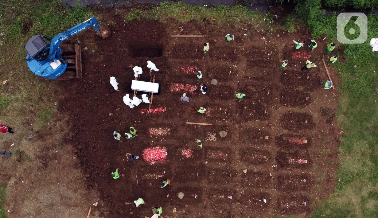 Foto udara memperlihatkan eksavator membantu proses penggalian makam jenazah dengan protokol COVID-19 di area khusus TPU Srengseng Sawah, Jakarta, Kamis (14/1/2021). Pada Selasa (12/1) lalu, 47 jenazah dimakamkan dengan protokol COVID-19 di TPU Srengseng Sawah. (Liputan6.com/Helmi Fithriansyah)