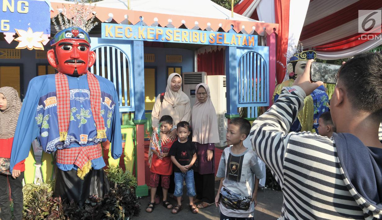 Warga berfoto di dekat ondel-ondel saat Lebaran Betawi di Monas, Jakarta, Minggu (21/7/2019).Untuk pertama kalinya Lebaran Betawi digelar di Monas yang diisi oleh beragam seni dan budaya masyarakat Betawi dalam rangka memeriahkan HUT DKI Jakarta. (merdeka.com/Iqbal S. Nugroho)
