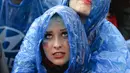 Tak peduli hujan mengguyur, fans cantik ini tetap menyaksikan Ozil cs berlaga melawan Amerika Serikat pada sebuah layar di Berlin pada 26 Juni 2014 (AFP PHOTO/CLEMENS BILAN)