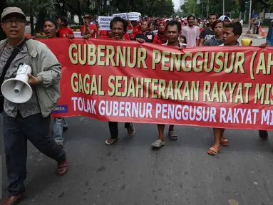 Massa Serikat Perjuangan Rakyat Indonesia (SPRI) membentangkan spanduk saat menggelar unjuk rasa di Balai Kota DKI Jakarta, Kamis (3/11). Mereka menolak penggusuran terhadap rakyat miskin dan menuntut penurunan harga sembako. (Liputan6.com/Faizal Fanani)