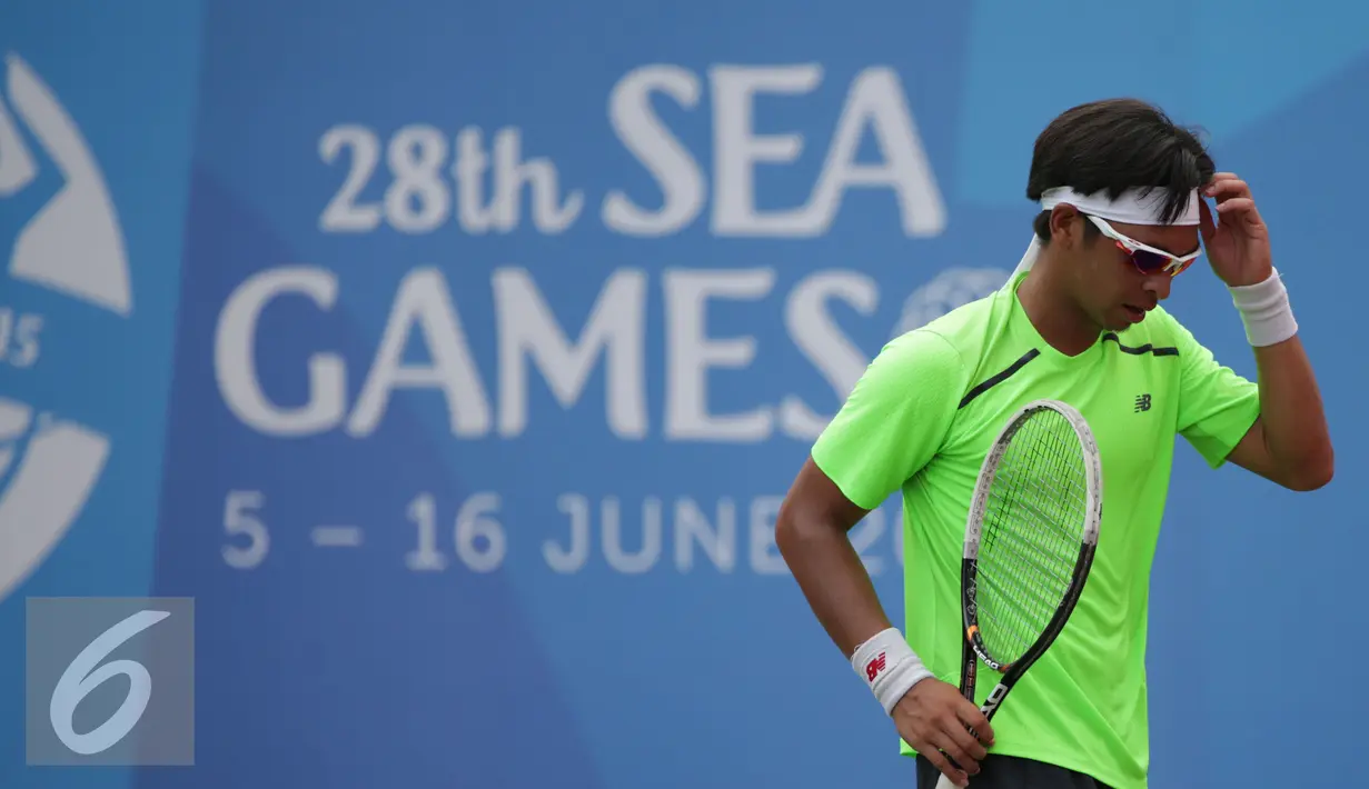 Petenis Indonesia, Christopher Rungkat tertunduk usai dikalahkan D Udomchoke (Thailand) di nomor beregu putra Sea Games 2015 di Kallang Tenis Centre, Singapura, Selasa (9/6/2015). Christopher Rungkat kalah 0-6, 4-6. (Liputan6.com/Helmi Fithriansyah)