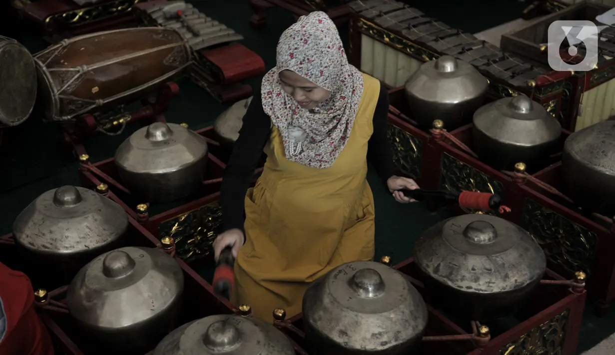 Pengunjung berlatih menjadi Nayaga atau penabuh gamelan saat lokakarya "Suara Dari Masa Lalu" di Museum Nasional, Jakarta, Minggu (22/12/2019). Lokakarya ini digelar dari 15 Desember 2019 hingga 5 Januari 2020. (merdeka.com/Iqbal S. Nugroho)