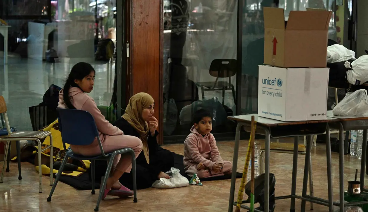 Sejumlah sekolah di Dekwaneh, utara Beirut, dikabarkan telah dialihfungsikan menjadi tempat penampungan bagi keluarga yang melarikan diri dari serangan udara Israel di pinggiran selatan Beirut (Dahieh) dan wilayah Lebanon Selatan. Tampak dalam foto, orang-orang duduk di dalam sebuah sekolah yang diubah menjadi tempat penampungan bagi para pengungsi di kota Dekwaneh, utara Beirut, Lebanon, pada Kamis 5 Maret 2026. (Joseph EID/AFP)