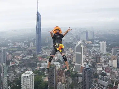 Seorang pelompat BASE terjun dari Menara Kuala Lumpur selama KL Tower International Jump Malaysia di Kuala Lumpur, Jumat (3/2/2023). Event wisata olahraga ini mengajak traveler penantang adrenalin untuk base jump, semacam terjun bebas, dari sisi atas menara di ketinggian sekitar 300 meter. (AP Photo/Vincent Thian)