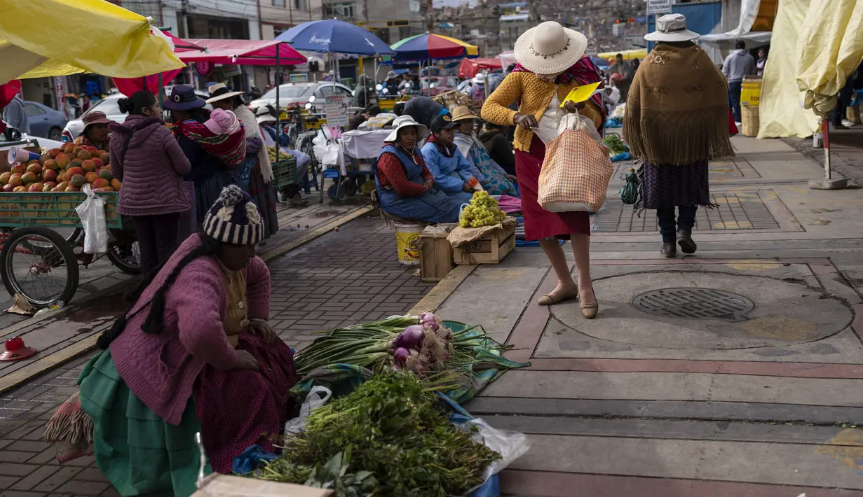 Perempuan menunggu pelanggan sambil menjual buah dan sayuran di pasar makanan populer di Puno, Peru, Minggu (29/1/2023). Pemerintah Peru membatasi kebebasan termasuk hak untuk berkumpul, setelah berminggu-minggu gejolak protes yang telah menewaskan sejumlah korban jiwa. (AP Photo/Rodrigo Abd)
