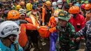 Tim gabungan dari berbagai unsur (termasuk TNI dan BPBD) mengerahkan alat berat seperti ekskavator untuk membantu pencarian di area yang aman. Tampak dalam foto, petugas penyelamat membawa korban dalam operasi penacarian di lokasi longsor di Desa Situkung, Banjarnegara, Jawa Tengah, pada Kamis 20 November 2025. (DEVI RAHMAN/AFP)
