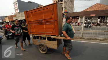 Warga Kampung Pulo menggunakan gerobak untuk memindahkan barang mereka pasca penggusuran, Jumat (21/8/2015). Pemprov DKI Jakarta merelokasi pemukiman padat di bantaran Kali Ciliwung ke Rusunawa Jatinegara. (Liputan6.com/Helmi Fithriansyah)